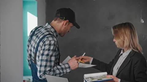 Man gestures as he writes on paper while woman looks on during job event Stock Footage 274527322