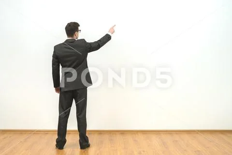 The man gesturing on the background of the white wall background Stock Photos