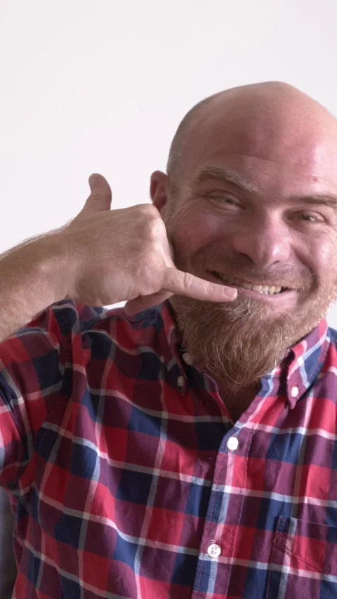 Man Gesturing "Call Me" with His Hands While Sitting on the Couch Stock Footage 293343842