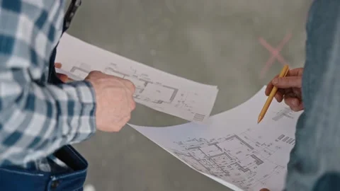 A man is gesturing at a drawing on paper with a pencil Stock Footage 268472308
