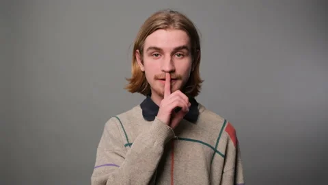 Man gesturing with finger on lips Stock Footage 229137089