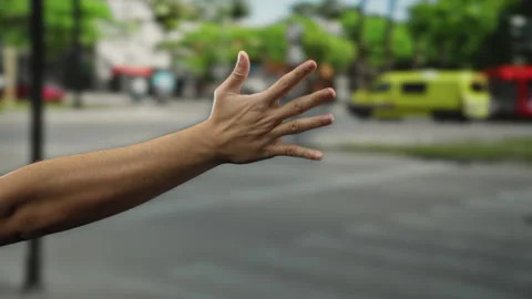 Man gesturing with hand outdoors on city street signaling across road with .. Stock Footage 310044008