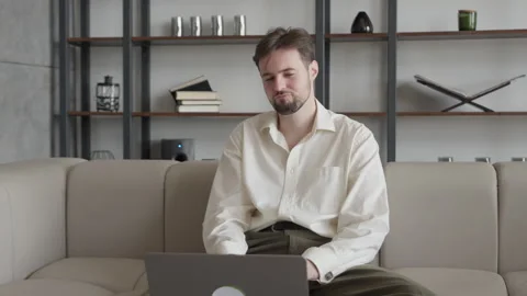 Man Gesturing With Hands During Video Call While Sitting On Couch At Home 스톡 동영상 306699242