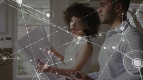 Man gesturing with tablet activating node web while woman pointing plans, web 스톡 동영상 331084909