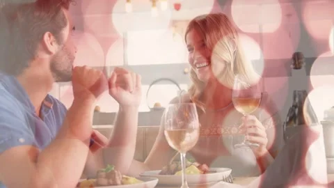Man gesturing, teasing woman while sharing meal, woman holding wine glass, bokeh Stock Footage 333689303