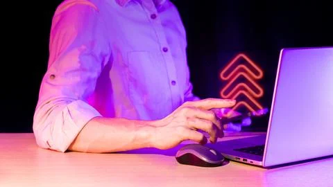 Man gesturing toward device with orange neon up arrows icon Stock Photos