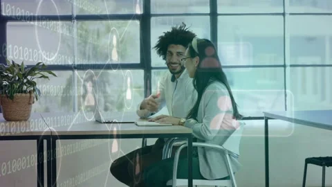 Man gesturing toward laptop sparking binary profile overlay while woman noting Stock Footage 334337974