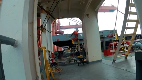 Man get down by the safety ladder from the hatch cover of the hold on huge cargo Video stock 169731767