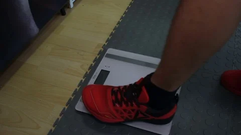 Man get up on the floor scales Stock Footage 70312552