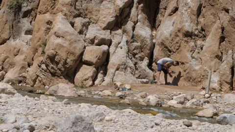 Man get refreshed near a river in Maroccan valley, Africa in 4K Stock Footage 92055293