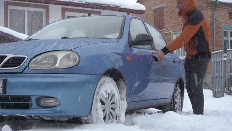 A man gets behind the wheel of a car in winter Stock Footage 221188008