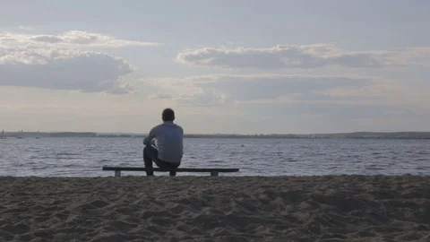 Man gets up from the bench by the lake Stockbeeldmateriaal 69858288