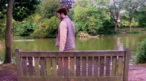 Man gets up from bench in slow motion. Leaves to left. Stock Footage 41761793