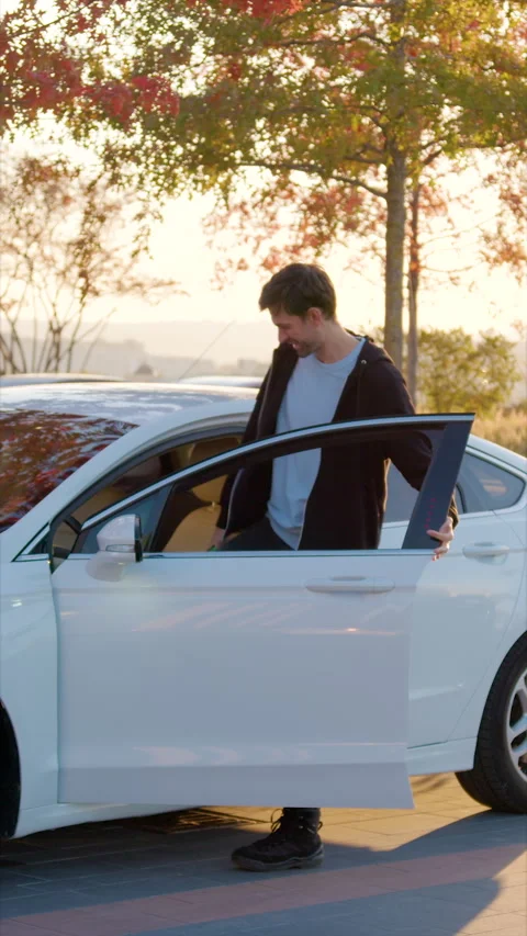 Man gets into car ordered through car sharing service at parking Stock Footage 300551300
