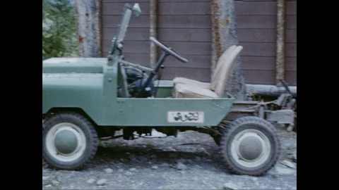 Man gets in a Jeep and lights a cigarette, 1950's Yellowstone Park Stock Footage 125836576