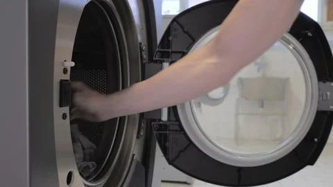 Man gets the laundry from the washing machine Stock Footage 202374899