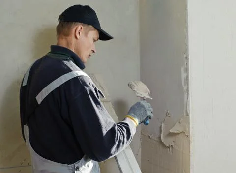 Man gets manually gypsum plaster Stock Photos