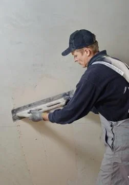 Man gets manually gypsum plaster Stock Photos