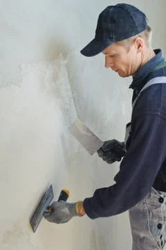 Man gets manually gypsum plaster Stock Photos