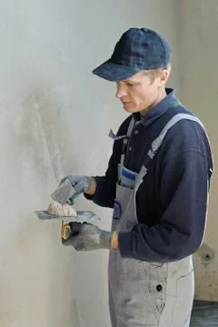 Man gets manually gypsum plaster Stock Photos