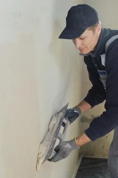 Man gets manually gypsum plaster Stock Photos