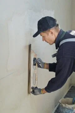Man gets manually gypsum plaster Stock Photos