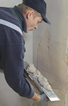 Man gets manually gypsum plaster Stock Photos