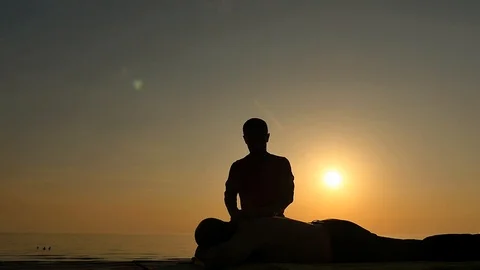 Man gets a massage at sunset isolated silhouete Stock Footage 89846865
