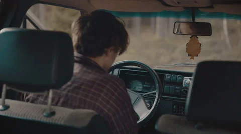 Man gets into the old car and writes a text on the phone Stock Footage 63333262