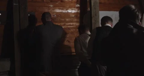 A man gets ordered at gunpoint to tie up two other man who have surrendered to Stock Footage 295037183