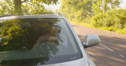 The man gets out of the broken car with the emergency lights on, and opens the Stock Footage 134166205