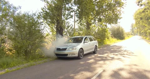 The man gets out of the broken smoking car that overheated. with the emergency Stock Footage 134166382