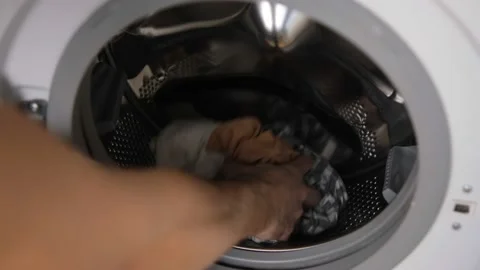The man gets out of the washing machine and things. Cylinder . unloading the Was Stock Footage 147089928