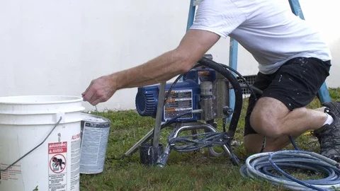 Man Gets Ready to Paint House with Paint Gun Stock Footage 95482540