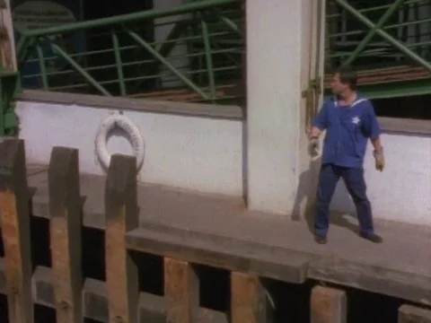 Man gets ready seeing the ferry coming and walks on the narrow strip of platform Stock Footage 79877792