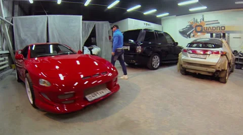 Man gets in red sport car at service workshop. Aerial view Stock Footage 37653602