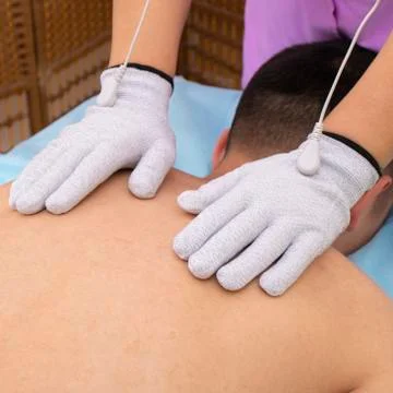 Man getting back massage, physiotherapy with white gloves Stock Photos