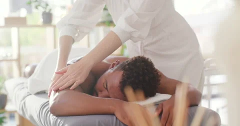 Premium Photo  Male masseur doing a lower back massage to a young