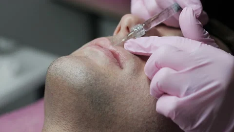 Man getting beauty injection for lips. Close-up of hands of cosmetologist making Stock Footage 167705366
