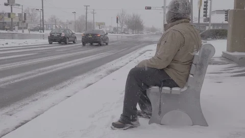 Man Getting up from Bus Stop and Leaving During Snow Storm Stock Footage 103700707