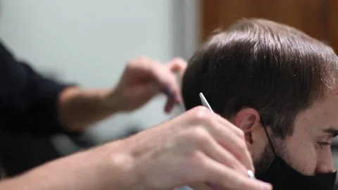 Man getting hair cut at the barber shop wearing protective mask during corona Stock Footage 139930554