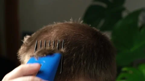 A man is getting a haircut with an electric clipper at home. Home haircut Stock Footage 169049751