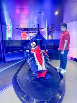 A man getting instructions on how to work the Formula 1 simulator aboard th.. Stock Photos