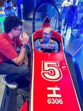 A man getting instructions on how to work the Formula 1 simulator aboard th.. Stock Photos