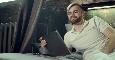 A man getting out of bed leaving his laptop Video stock 135113786