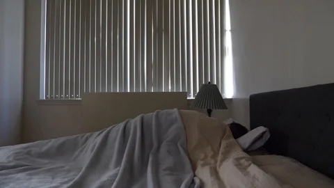 Man getting out of bed lets the sunshine in Stock Footage 113476257