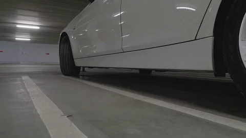 Man getting out of a car parked in a garage Stock Footage 85402211