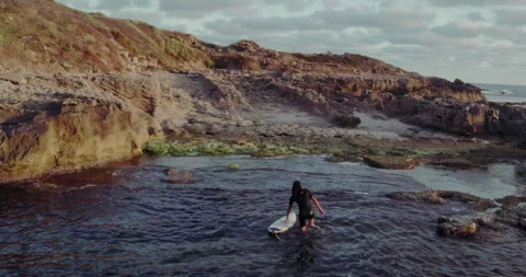 Man getting out of the ocean with his surfboard aerial Stock Footage 275576615