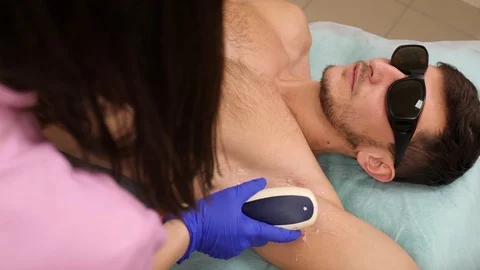 Man getting permanent laser armpit hair removal at beauty salon Stock Footage 102399544