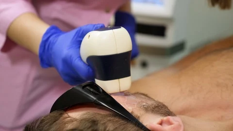 Man getting permanent laser facial hair removal at beauty salon Stock Footage 102399871